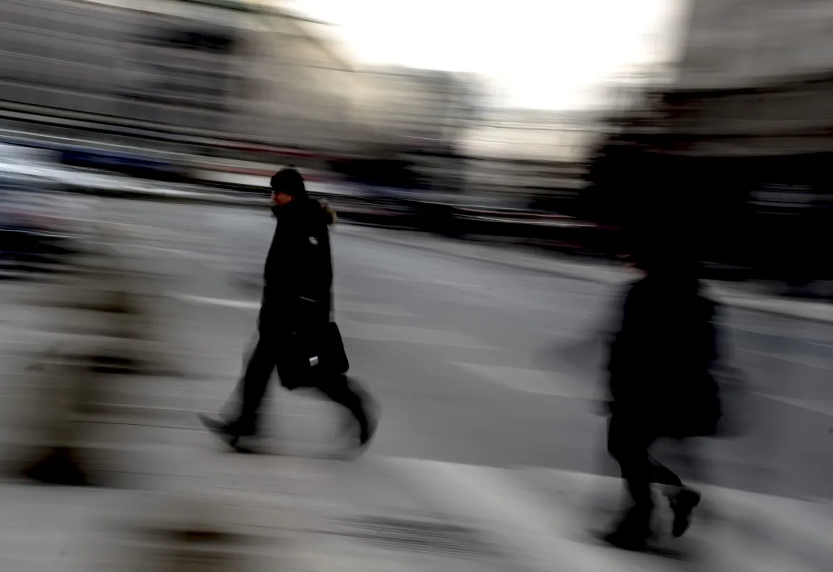Two black-clad pedestrians passing each other in motion blur